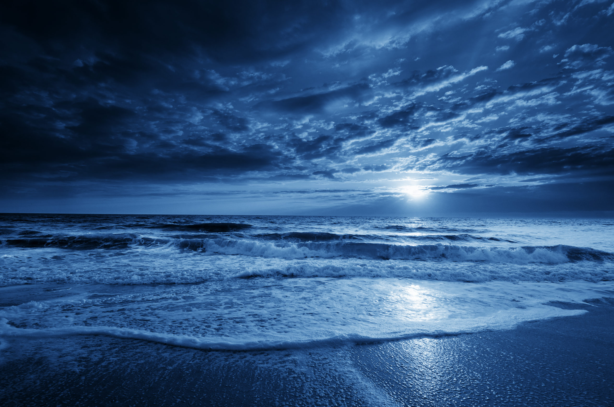 Midnight Blue Coastal Moonrise With Dramatic Sky and Rolling Waves